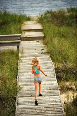 girl running on boardwalk