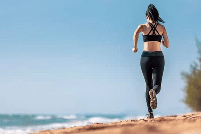 girl beach running with shoes on