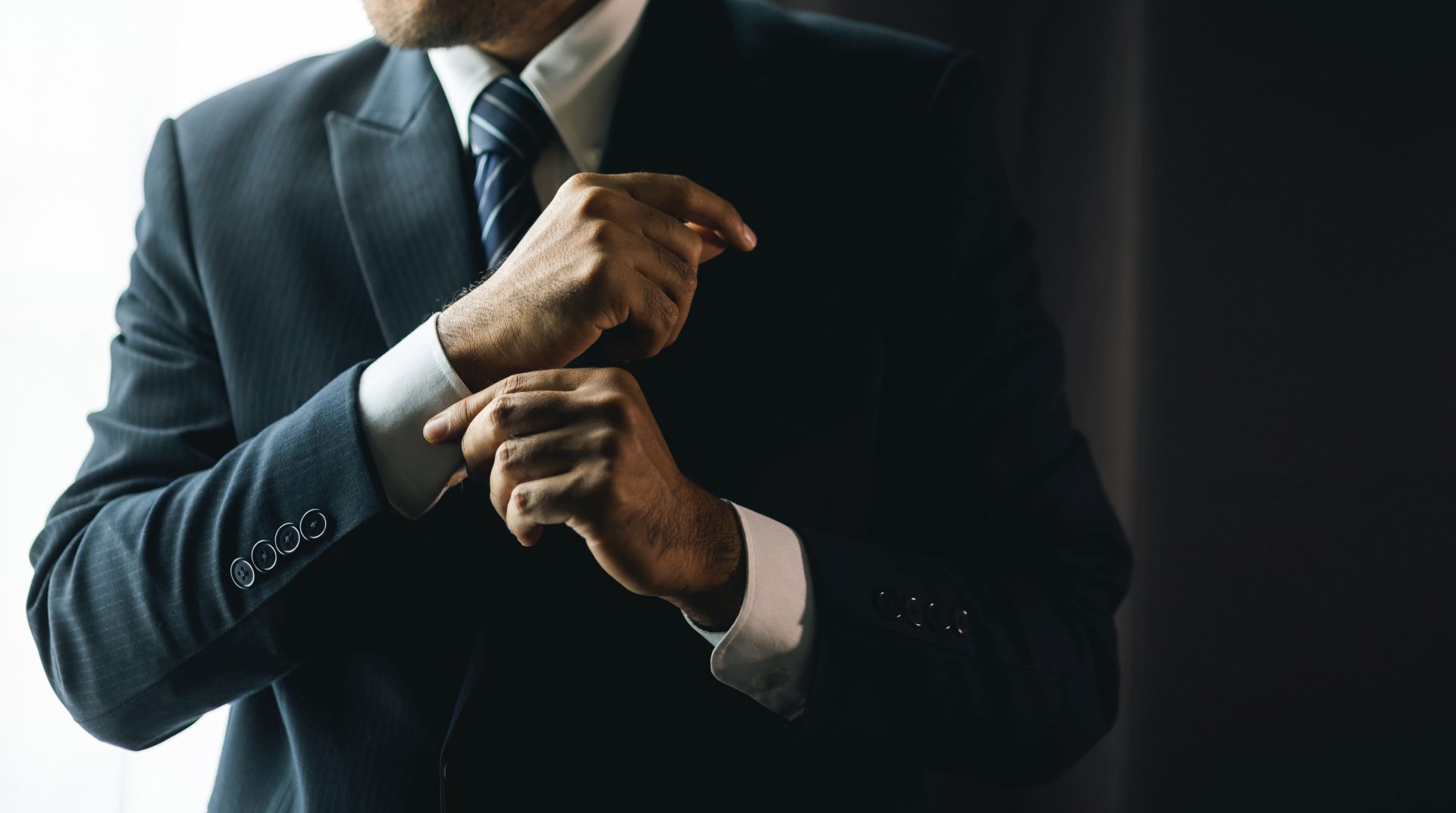 Confident businessman buttoning or adjust classic blue suit