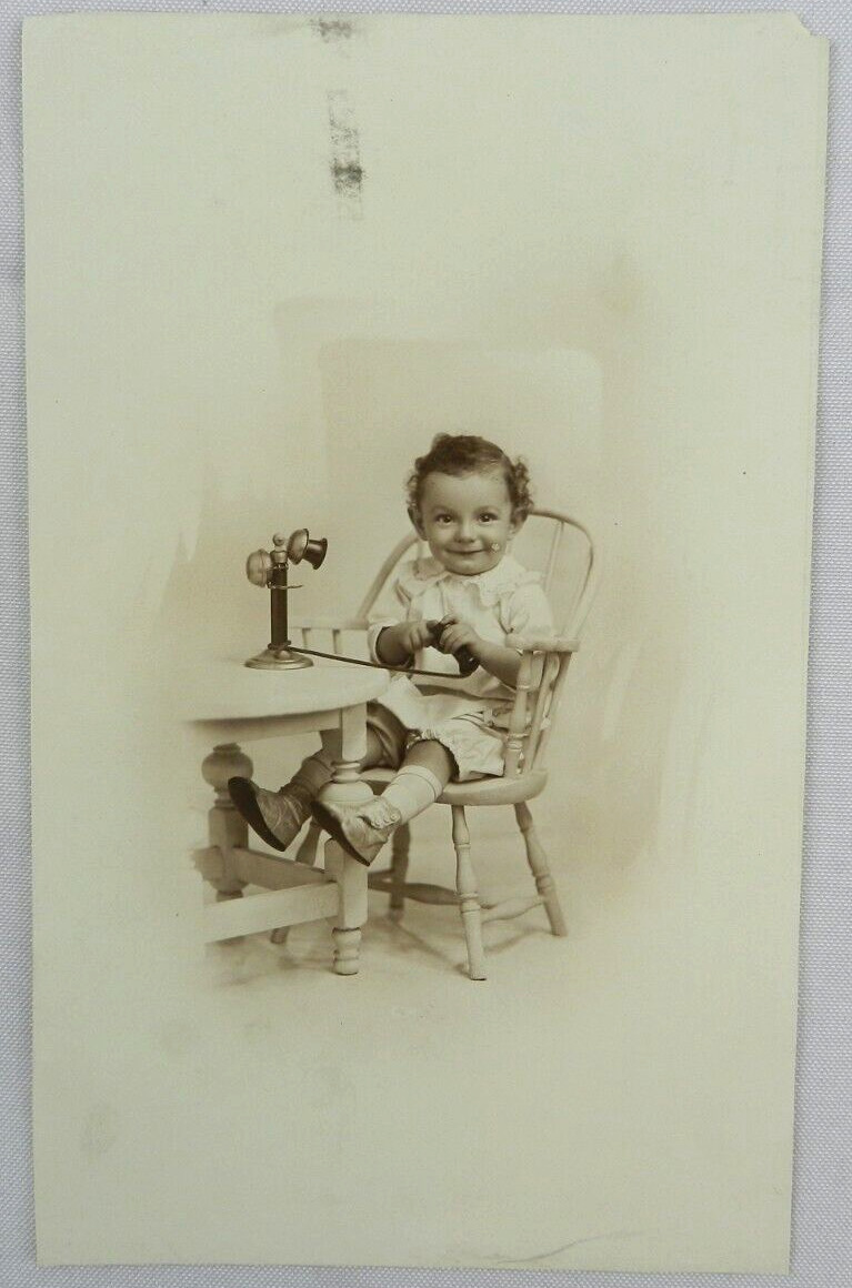 Infant Child in Wooden Chair Toying with Microphone - c.1900s Cabinet Card