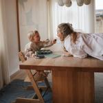 mushie Long Sleeve Baby Bib | Water Resistant Adjustable Fit for Ages 6-24 Months (Dinos)