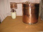 Antique Copper Moonshine Still with Glenmore Whiskey Jug