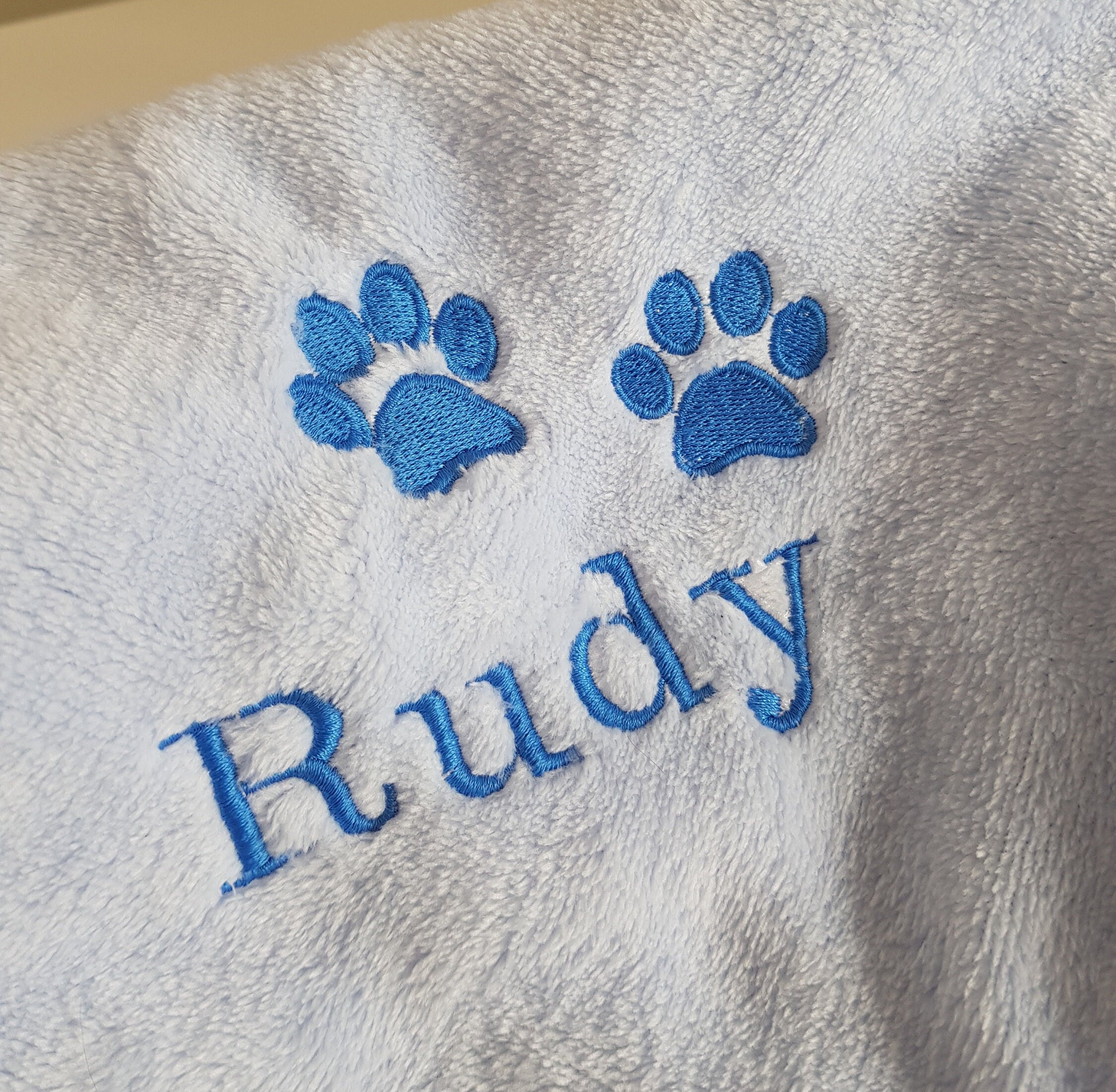 Custom embroidered pet blanket with paw print and name